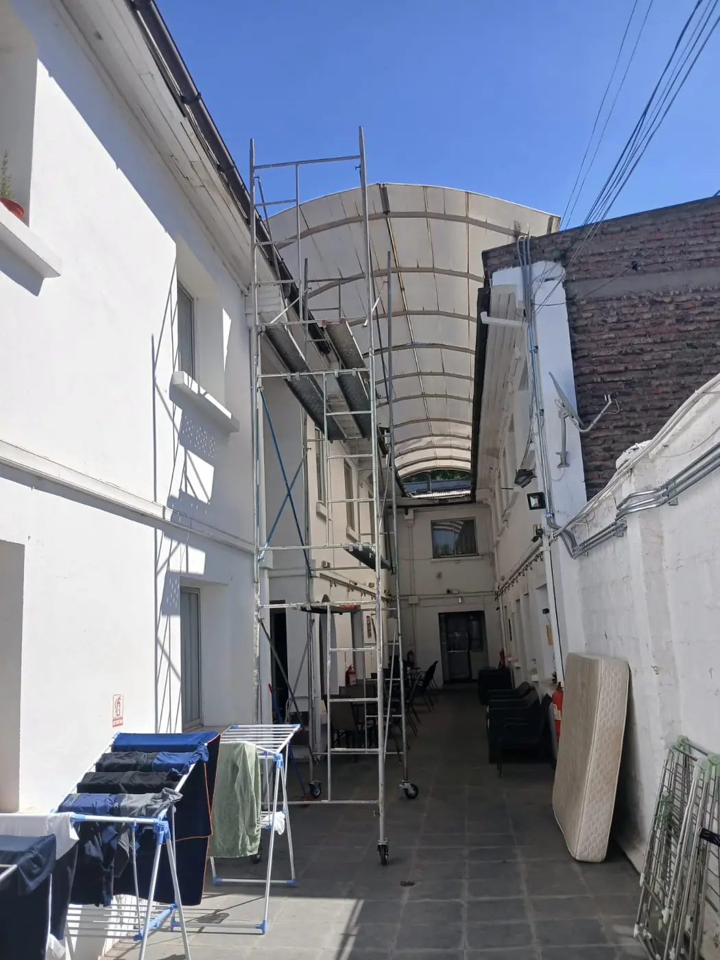 Torre de andamio en pasillo entre edificios con cubierta - Servicios Urgentes